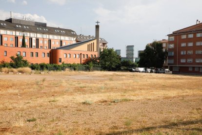 La parcela está entre la iglesia y el edificio rojo.