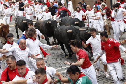 Los toros de la ganadería sevillana de Miura entran en la curva de Mercaderes durante el séptimo encierro de los Sanfermines 2026, este lunes en Pamplona. EFE/Jesús Diges.
