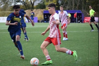 Ángel Ochoa, futbolista de la Peña, controla el balón ante la presencia de Lamine Yamal.