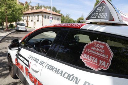 Uno de los vehículos de una autoescuela leonesa con una pegatina con el lema de la protesta del próximo jueves.