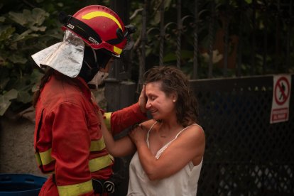 Una efectivo del UME consuela a una vecina de Piedralaves tras quemarse la casa de su padre.