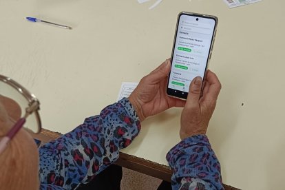 Una mujer utiliza en su móvil la nueva app para mejorar la atención a personas con deterioro cognitivo