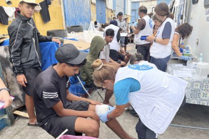Sanitarios atienden en el Tarajal a jóvenes migrantes que están heridos.