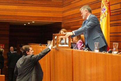 El presidente Mañueco introduce una papeleta en la votación secreta.