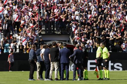El árbitro José María Sánchez Martínez (c) habla con miembros de ambos equipos antes de comunicar la suspensión definitiva del partido entre el Rayo Vallecano y el Athletic de Bilbao, después de que la afición rayista protestara contra la gestión de Martín Presa lanzando aviones de papel y bolas pequeñas de plástico, este sábado. EFE/ Mariscal.