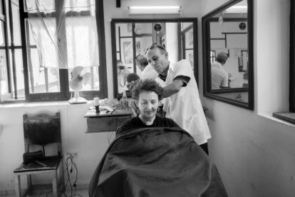 Una escena cotidiana en una peluquería, fotografiada en blanco y negro.