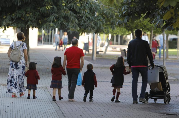 Una padres llevan a sus hijos al colegio en León.