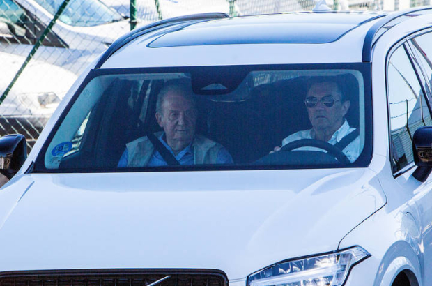 El rey emérito, Juan Carlos de Borbón, tras ser recibido por su amigo Pedro Campos (d) en el aeropuerto de Vigo. SALVADOR SAS