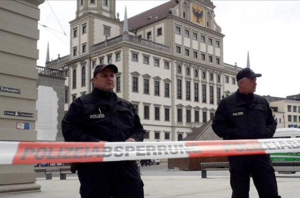 Dos policias vigilan junto al cordón de seguridad colocado en las proximidades del Ayuntamiento de Augsburgo, en Alemania.