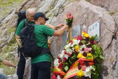 Miembros de Greim colocando flores junto las placas.