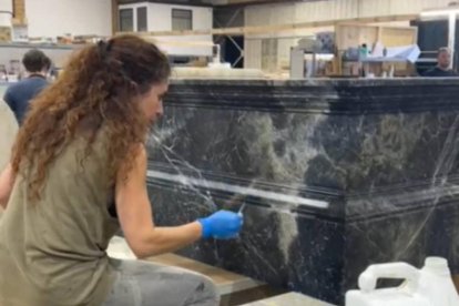 La artista leonesa Rut Villamagna dando aspecto de mármol a un bloque de madera.