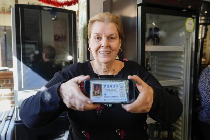 Tina, propietaria del restaurante el Leonés de Marbella posa con un décimo del Gordo del Sorteo Extraordinario de la Lotería de Navidad, este lunes.