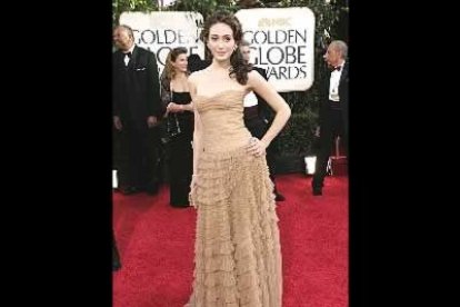 Emmy Rossum pisa la alfombra.