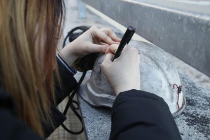 Un familiar escribe en un caso el nombre de una de las víctimas del accidente minero. RAMIRO
