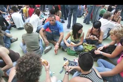 Un grupo de jóvenes, bocata en mano, carga fuerzas ante la intensa noche de rock que les espera.