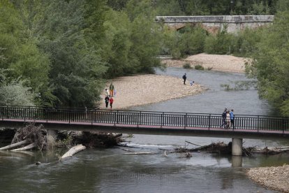 Coronavirus. Paseo mañanero con los niños por las inmediaciones del río Bernesga, con los restos de las riadas que ocurrieron en febrero.