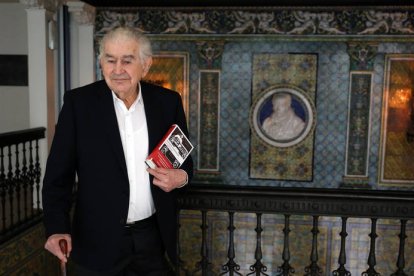 Antonio Gamoneda junto a la réplica de la placa conmemorativa que figura desde ayer en Oviedo en su casa natal en la calle Melquíades Álvarez. J. L. CEREIJIDO