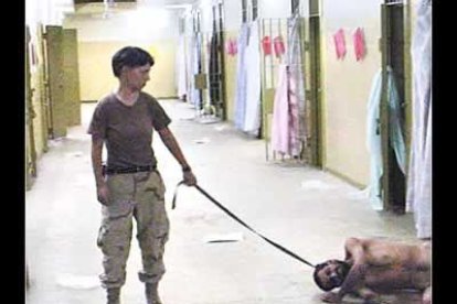 En una de las fotos se ve a una soldado de Estados Unidos que arrastra con una correa a un prisionero iraquí desnudo.