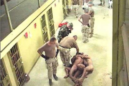 Un grupo de prisioneros desnudos obligados a tumbarse unos encima de otros.