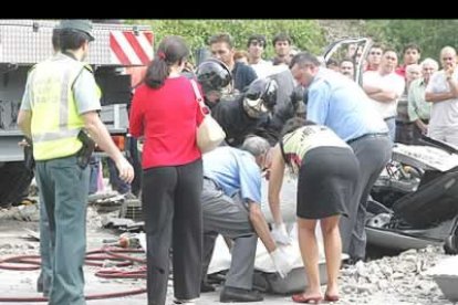 Momento en el que los miembros del equipo judicial, ayudados por los bomberos y la Guardia Civil, introducen el cuerpo de uno de los fallecidos en una caja para su translado al tanatorio.