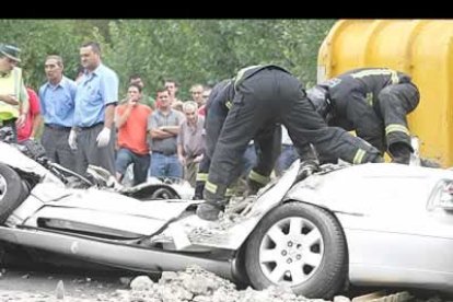 Los bomberos rescatan el cuerpo sin vida de uno de los conductores que se vieron sorprendidos por el accidente.