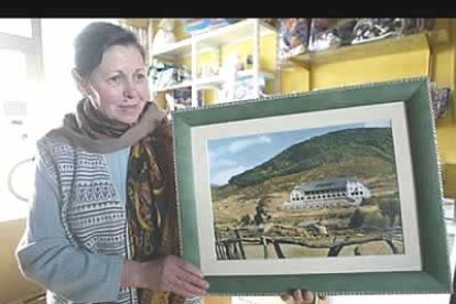 Daría Domínguez, vecina de Riaño, muestra una fotografía antigua del desaparecido parador