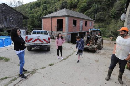 Carmel Pol y Óscar Juanes, con sus dos hijas (centro), en la plaza del pueblo de Bargelas, municipio de Vega de Valcarce. ANA F. BARREDO