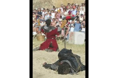 El caballero vencedor brinda a los asistentes la muerte de su contrincante, que yace en la arena con una daga mortal clavada en su costado.