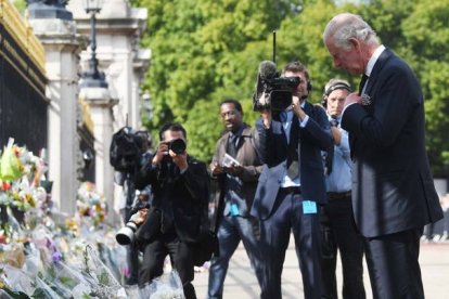 El rey recorrió el pasillo de flores y mensajes que los ingleses han dejado a las puertas de Buckingham. NEIL HALL