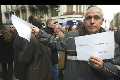 Un vecino reparte entre los manifestantes un escrito en el que se lee «Arzallus apunta ETA dispara».