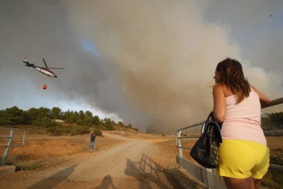 Una vecina observa las labores de extinción. RAMIRO
