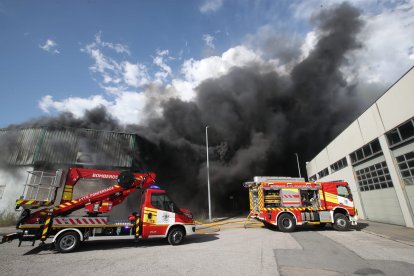 Vehículos de los bomberos frente a la intensa humareda. L. DE LA MATA