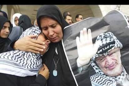 Dos mujeres, vistiendo ya el luto, lloran la muerte del rais.