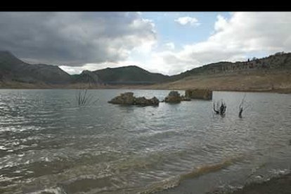Las aguas, arrastradas por la corriente, chocan contra los restos de las casas, sepultadas por el embalse