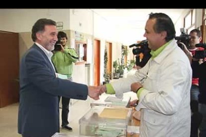 El Delegado del Gobierno en Castilla y León, Miguel Alejo, saluda al presidente de su mesa después de votar.