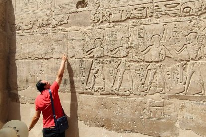 El guía egipcio señala los relieves en uno de los muros del templo de Kom Ombo. GAITERO