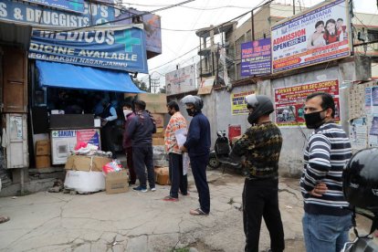 Varias personas hacen cola en la farmacia en Jammu, India. JAIPAL SINGH