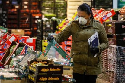 Una minorista comprueba la mercancía en una de las naves de frutas y verduras de los Mercados Centrales de Abastecimiento de Sevilla (Mercasevilla), que funciona con normalidad. JOSÉ MANUEL VIDAL