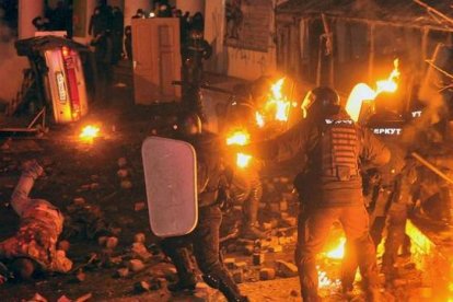 Unos manifestantes se enfrentan con la policía antidisturbios durante una manifestación de la oposición en el centro de la capital ucraniana. AFP PHOTO / GENYA SAVILOV