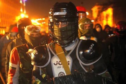 Manifestantes vestidos con equipo de protección improvisada se preparan para enfrentarse con la policía en el centro de Kiev . AP / SERGEI GRITS