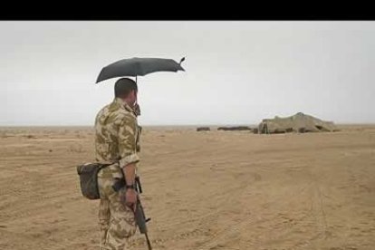 Un sargento del ejército británico usa su paraguas para protegerse de la arena en el norte del desierto de Kuwait.