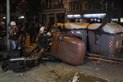 Varios manifestantes vuelcan contenedores. ANDREU DALMAU