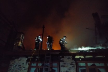 Las primeras tareas de los efectivos del Servicio de Extinción de Incendios y Salvamento de Ponferrada se centraron en evitar la propagación a la vivienda colindante y a un depósito de gasóleo. BOMBEROS DE PONFERRADA
