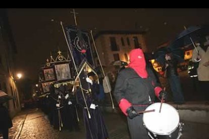 Los Hermanos procesionaron por la calle no más de 20 metros ante una plaza prácticamente vacía, ataviados con la tradicional túnica negra y capillo y bocamangas rojas.