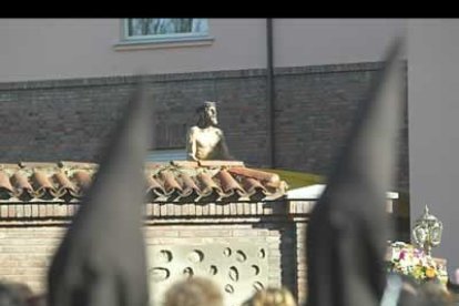 Entre los tejados del caso antiguo de León y los capillos de los papones se divisa la imagen de Jesús.