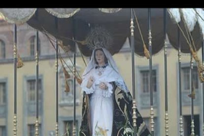 Un grupo de mujeres puja el paso de la Madre de la Paz.