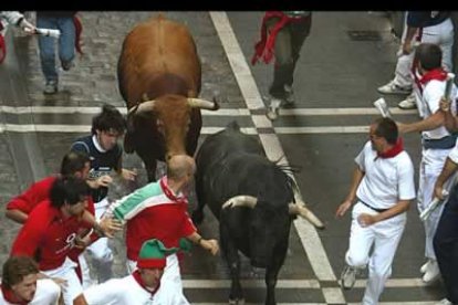 Los corredores se apresuran, con el periódico en la mano a abandonar las zonas peligrosas que podrían llevarles a ser arrollados por las reses.
