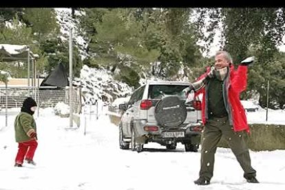 Otra imagen poco frecuente. También nevó en las Baleares. En la imagen, un padre y su hijo juegan en la sierra de la Tramuntana.