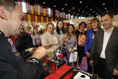 Cendón prueba un pedazo de cecina, con cargos del PSOE. RAMIRO