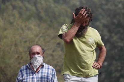 Dos vecinos muestran su impotencia ante el avance de las llamas.